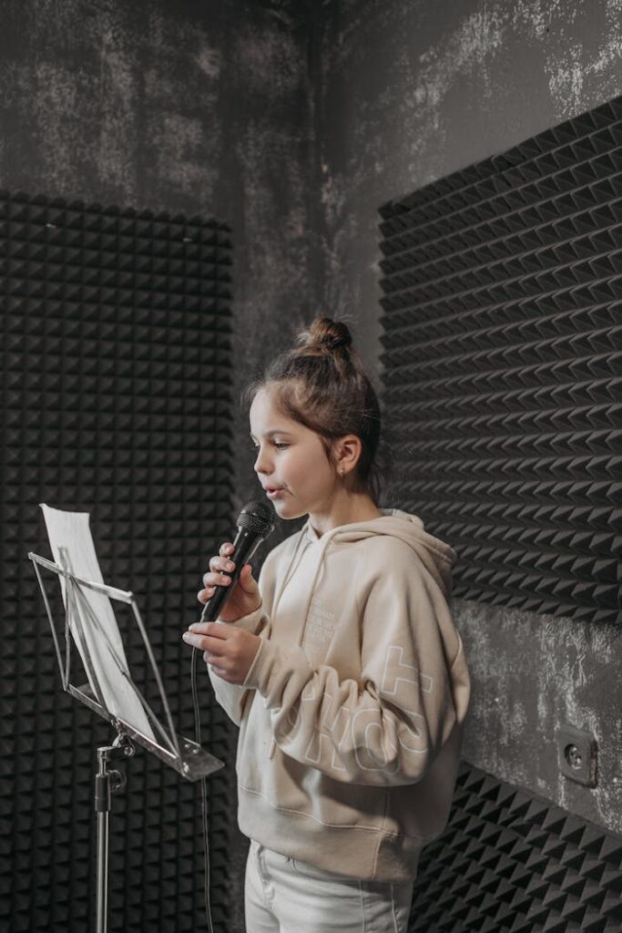 The Art of Drawing Readers In: Your attractive post title goes here A young girl rehearses lyrics in a soundproof studio with a microphone and music stand.